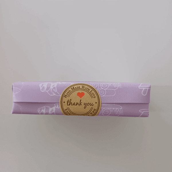 A clay soap with purple packaging and thank you sticker on it.
